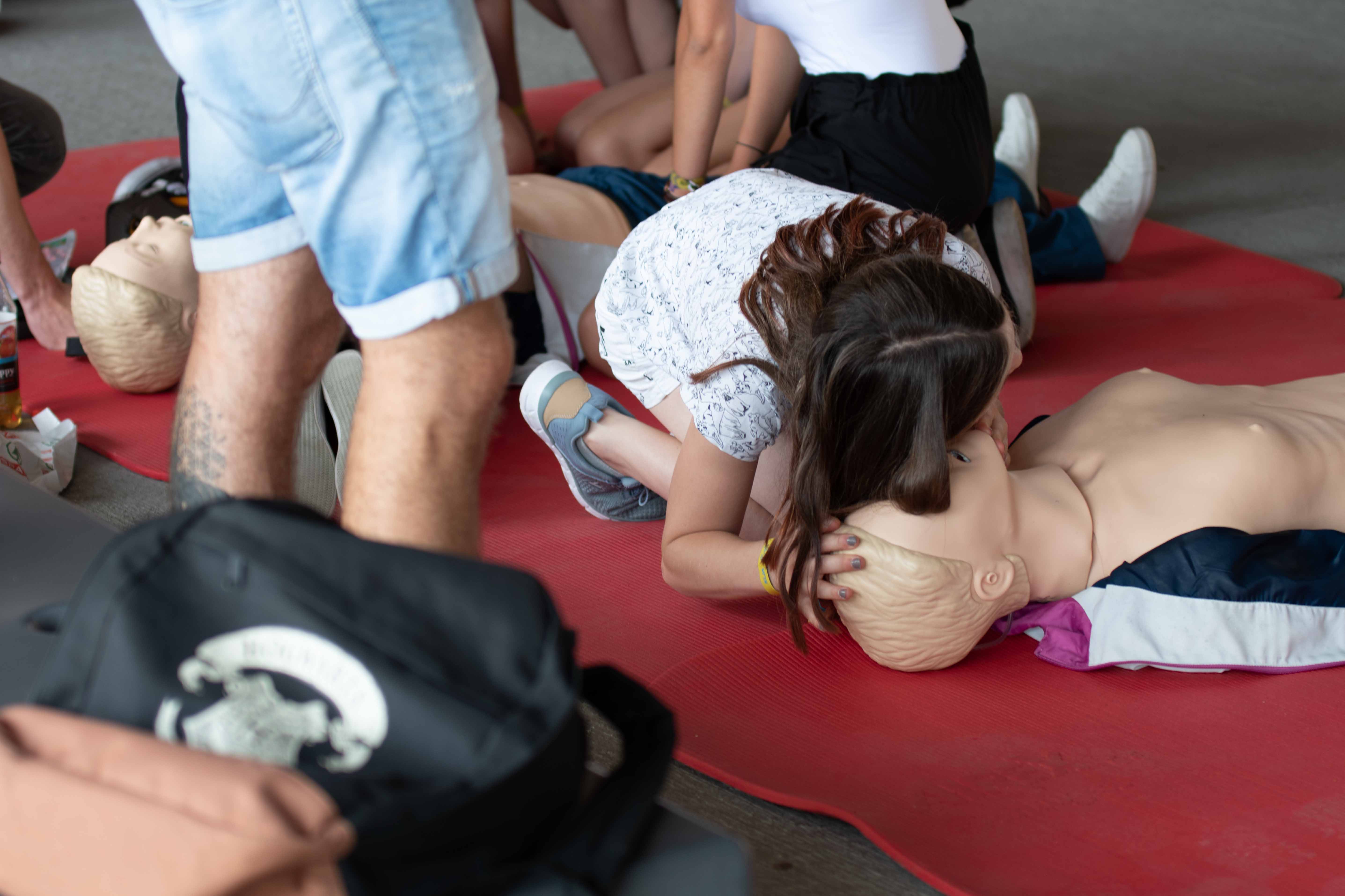 eine Persone übt Reanimation an einer Puppe