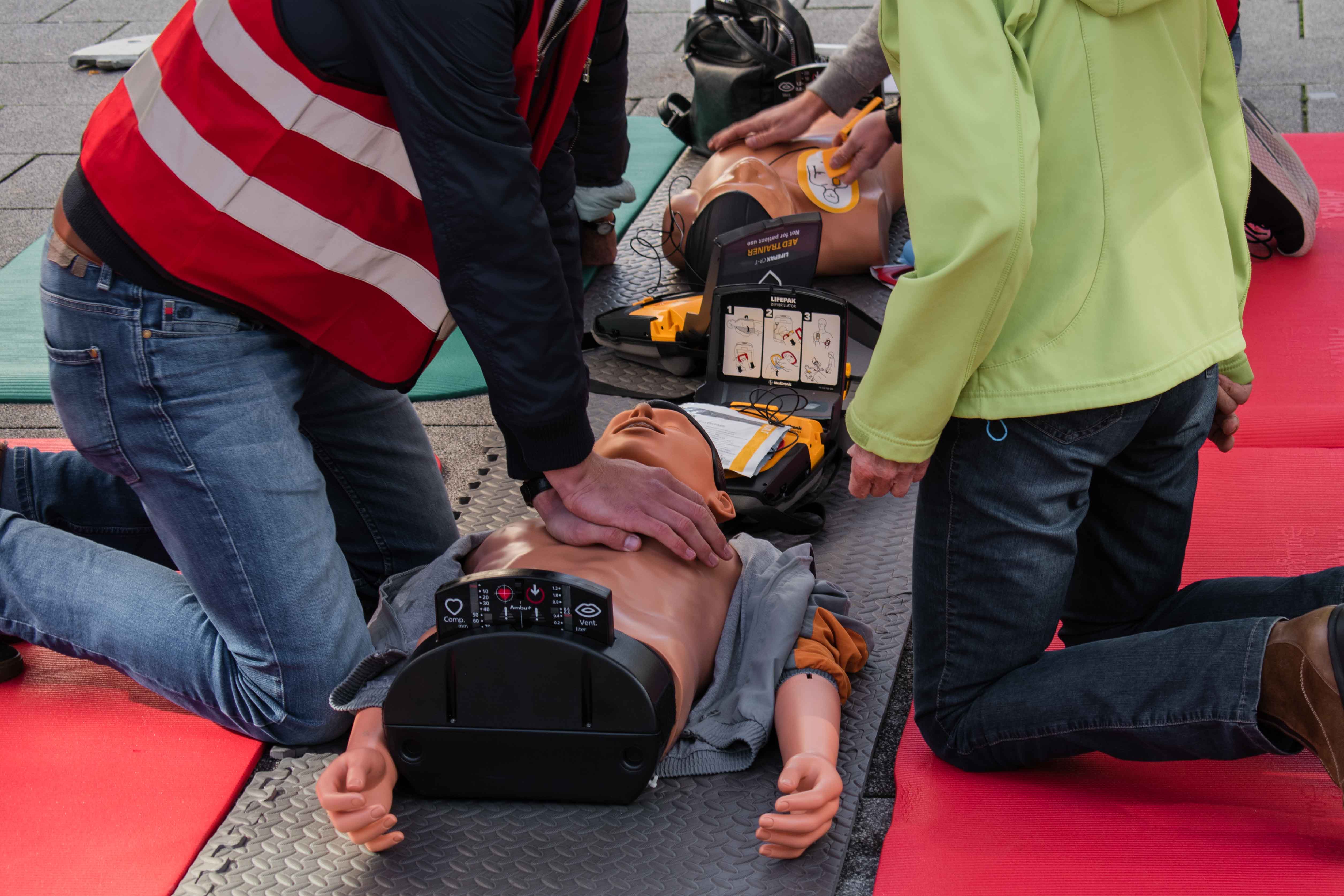 zwei Personen üben Reanimation an einer Puppe